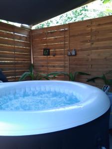a jacuzzi tub in a room with a wooden wall at charmante maison in Les Avirons