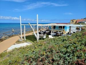 a house on the beach with the ocean in the background at Casa Aniste in Castelsardo