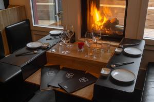 a table with plates and wine glasses and a fireplace at Suite Apartments by Hotel Gabbani in Lugano