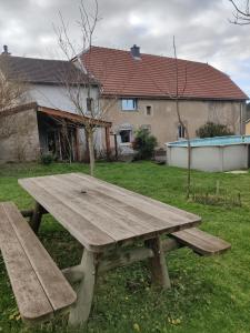 a wooden picnic table in front of a house at Au Jardin d'Isa in La Résie-Saint-Martin