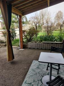 a patio with a table and chairs on a rug at Au Jardin d'Isa in La Résie-Saint-Martin +7 photos