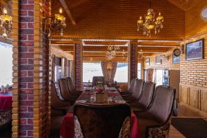 a dining room with a long table and leather chairs at Hotel Village Walk in Sonāmarg