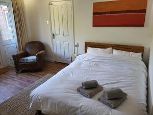 a bedroom with a white bed with two pillows on it at Little Brookfield in Lymington