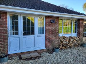 a red brick house with blue doors and windows at Little Brookfield in Lymington