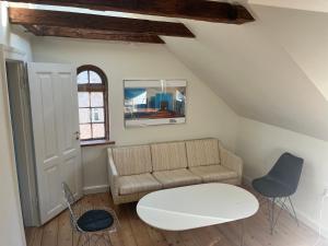 a living room with a couch and a table at Charming Heritage Townhouse in Odense