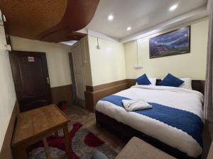 a bedroom with a large bed with blue pillows at Hotel Sakura & Tandoori Restaurant in Kathmandu