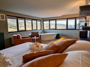 a bedroom with a large bed with a tub and windows at El Patio Hotel in Corciano