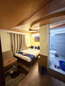 a small bedroom with a bed and a bathroom at Hotel Sakura & Tandoori Restaurant in Kathmandu