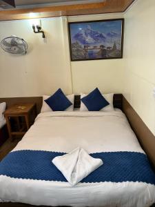 a bedroom with a large bed with blue pillows at Hotel Sakura & Tandoori Restaurant in Kathmandu