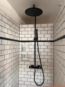 a shower in a bathroom with white tiled walls at Charming Heritage Townhouse in Odense +23 photos