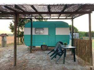 a green and white trailer parked under a fence at Agriturismo Barattis in Piombino