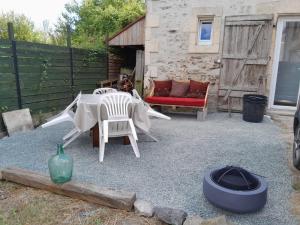 a patio with a table and chairs and a fire place at 35 m2 independent studio in Marillet