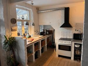 a kitchen with white counters and a stove top oven at Charming Heritage Townhouse in Odense