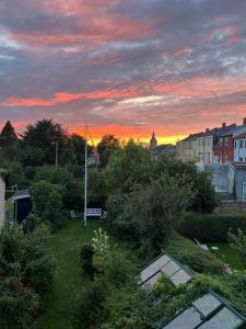 a sunset in a city with trees and buildings at Charming Heritage Townhouse in Odense