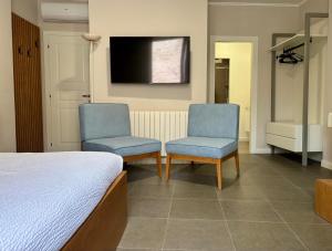 a bedroom with two chairs and a bed and a tv at Camere di Bianca in Foligno