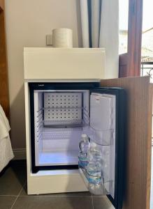 an open refrigerator with bottles of water in it at Camere di Bianca in Foligno