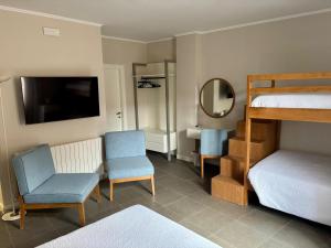 a bedroom with a bunk bed and two chairs and a mirror at Camere di Bianca in Foligno