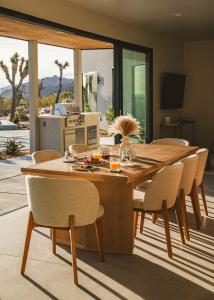 a wooden table and chairs in a living room at Pool - Spa - Fire pit - Views - BBQ - Bella Nova in Joshua Tree