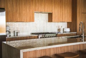 a kitchen with wooden cabinets and a stove top oven at Pool - Spa - Fire pit - Views - BBQ - Bella Nova in Joshua Tree