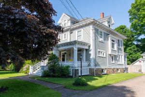 a large white house with a porch at The Boardwalk Inn in Summerside