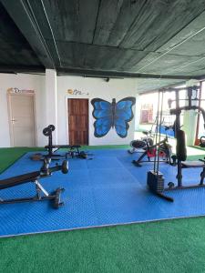 a gym with several tread machines and a butterfly on the wall at Basi Resort in Nombre de Dios