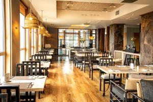 a restaurant with wooden tables and chairs and windows at Solace Hotel Puerto Varas in Puerto Varas