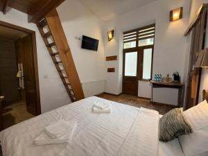 a bedroom with a bed with white sheets and a window at Vista Rustic Room in Sibiu