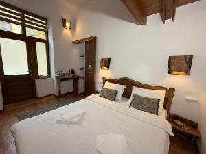 a bedroom with a large white bed and a window at Vista Rustic Room in Sibiu