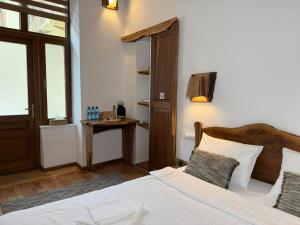 a bedroom with a large bed and a table at Vista Rustic Room in Sibiu