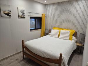 a bedroom with a bed with yellow and white pillows at Chez Bouju in Castetnau-Camblong +30 photos