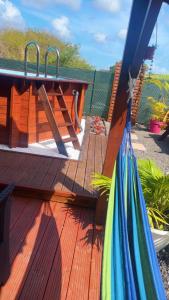 a wooden deck with a table and a towel at Villa Eden hibiscus in Petit-Canal