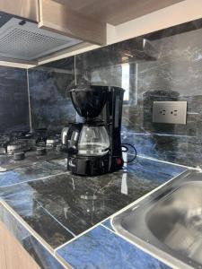 a coffee maker sitting on top of a kitchen counter at aparta hotel del toro in Puerto Triunfo