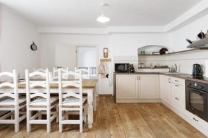 a kitchen with white cabinets and a table and chairs at Chalupa U Lávky in Lasenitz +21 photos