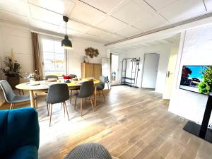 a dining room and living room with a table and chairs at Central City Apartment 1 with Mountain View in Zweisimmen