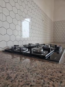 a stove top in a kitchen with a tile wall at SEED-Aeroport Nsimalen Yaounde in Nsimalen