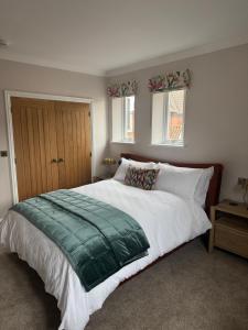 a bedroom with a large bed and two windows at Half Moon Nest - Refurbished throughout for 2026 in Diss