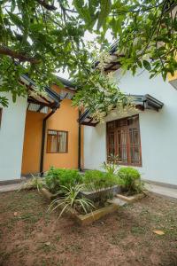 a white building with windows and plants in front of it at Airport Serenity Villa - Near Colombo Airport in Katunayaka