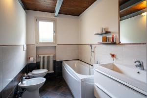 a bathroom with a tub and a toilet and a sink at Urban Nest in Forlì +30 photos