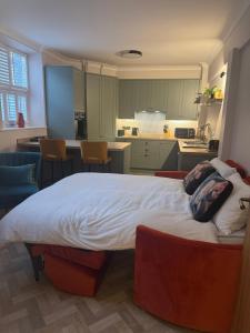a bedroom with a large bed and a kitchen at Half Moon Nest - Refurbished throughout for 2026 in Diss