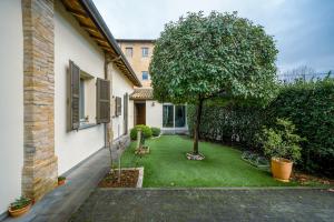 a small yard with a tree and a house at Urban Nest in Forlì