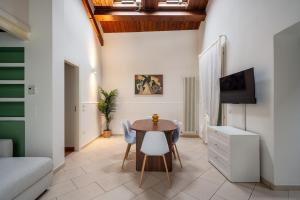 a room with a table and chairs and a tv at Urban Nest in Forlì