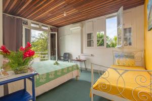 a room with a bed and a table and windows at Villa Les Violettes in Morne-à-lʼEau