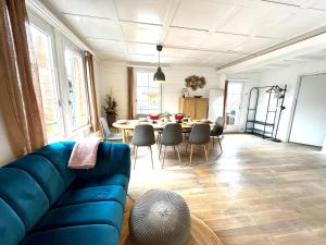 a living room with a blue couch and a table at Comfy, Spacious and Central Duplex Apartment in Zweisimmen