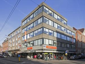 a tall building on a city street with a street at easyHotel Amsterdam City Centre South in Amsterdam