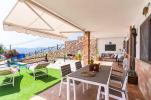 a patio with a table and chairs and a tv at Villa for 4 with feature pool & great reviews in Bédar
