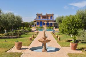 a house with a fountain in front of a yard at Bluegreen Guest House Marrakech in Aït Amara