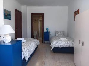 a small bedroom with two beds and a lamp at Casa do Luiz in Lisbon