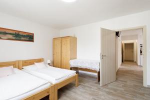 a bedroom with two beds and a closet at Chalupa U Lávky in Lasenitz