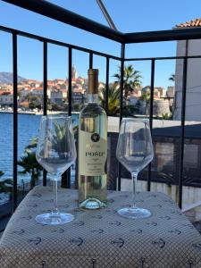 a bottle of wine and two wine glasses on a table at The Korčula Outlook - Bedrooms in Korčula