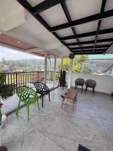 a patio with chairs and a table on a balcony at Mount Elbrus Home stay in Devikolam